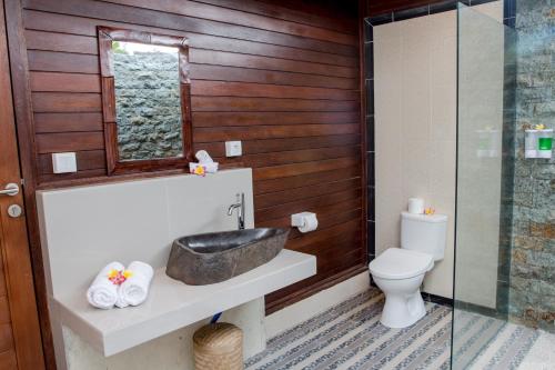 a bathroom with a sink and a toilet at Seaside Huts Lembongan in Nusa Lembongan