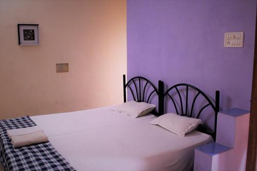 a bedroom with a black and white bed with two pillows at Casa Domingos Guest House in Calangute