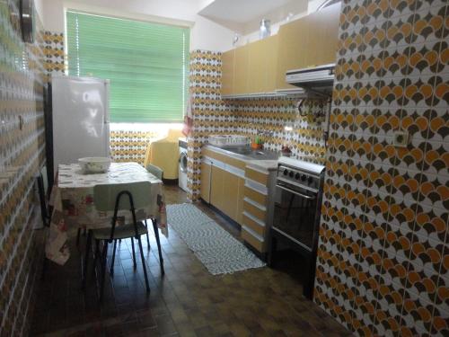 a kitchen with a table and a stove and a sink at Apto paio-pires in Seixal