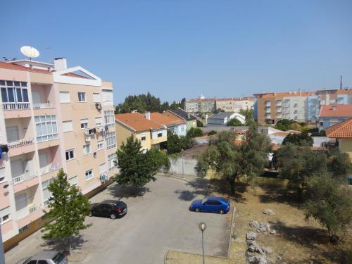 a city street with cars parked in a parking lot at Apto paio-pires in Seixal
