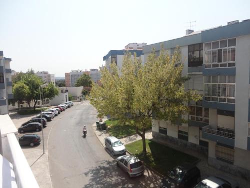a street with cars parked in a parking lot at Apto paio-pires in Seixal