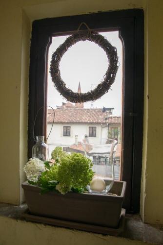 a window with a wreath and a bowl of plants at La Casa sui Tetti in Novi Ligure