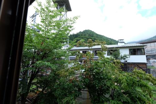 a view from a window of a house with a tree at Tsuyukusa in Takayama