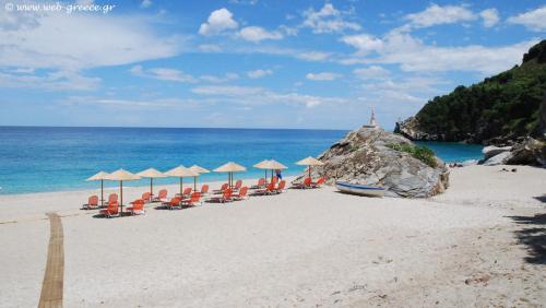 a group of chairs and umbrellas on a beach at Iakovakis Suites & Spa in Koropi