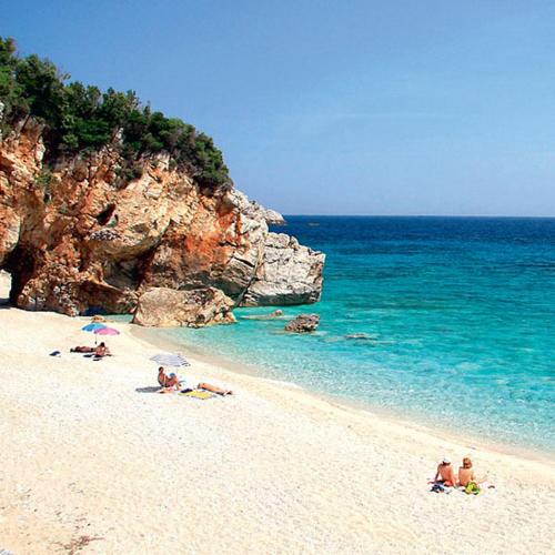 a group of people on a beach near the ocean at Iakovakis Suites & Spa in Koropi