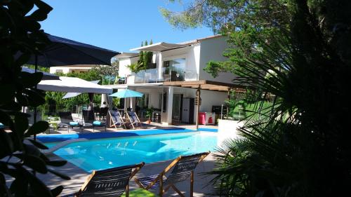 a swimming pool with chairs and a house at Villa Perle De La Mer in Saint-Aygulf