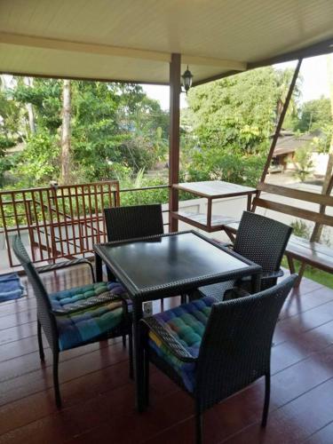 a table and chairs on a screened porch with a table and chairs at Boons Bungalow Ban Krut in Ban Krut