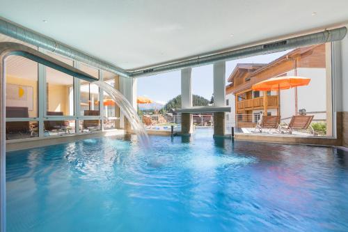 a swimming pool with a water fountain in a building at Hotel Blattnerhof in Blatten bei Naters