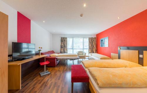 a hotel room with two beds and a flat screen tv at Hotel Blattnerhof in Blatten bei Naters