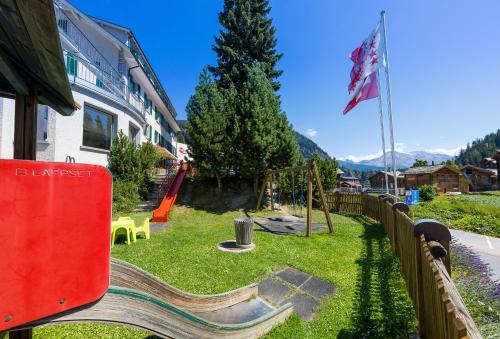 a playground with a slide and an american flag at Hotel Blattnerhof in Blatten bei Naters