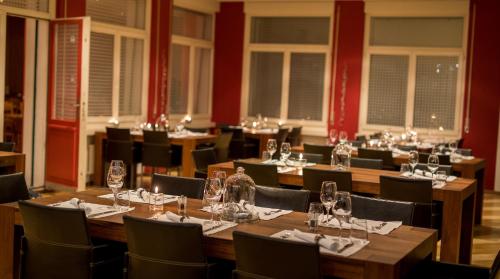 a dining room with tables and chairs with wine glasses at Hotel Blattnerhof in Blatten bei Naters