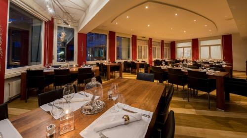 a restaurant with a long wooden table and chairs at Hotel Blattnerhof in Blatten bei Naters