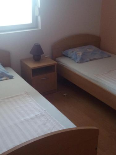 een slaapkamer met 2 bedden en een lamp op een nachtkastje bij Apartment Marta in Nin