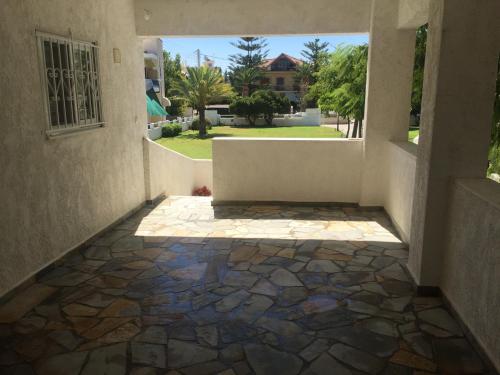 an empty hallway with a tile floor and a window at Phoenix Beachside Condos in Kokóni