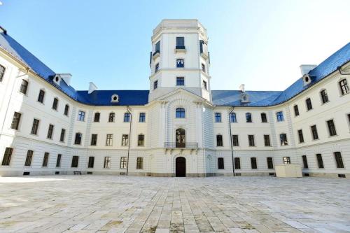 a large white building with a tall tower at Borostyán Vendégház Eger in Eger