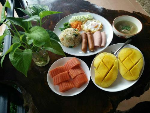 a table with plates of food on a table at Ouidee Resort in Na Noi