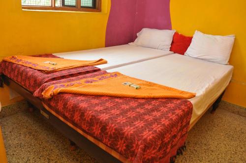 two beds in a room with two bags on them at Vicky's Home Stay Hampi in Hampi