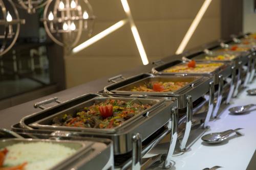 a row of trays of food on a table at Executives Hotel - KAFD in Riyadh