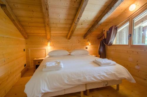 レ・ジェにあるChalet Ferme des Amisの木造キャビン内のベッド1台が備わるベッドルーム1室を利用します。