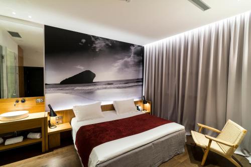 a bedroom with a bed and a desk and a sink at Aire Hotel & Ancient Baths in Almería