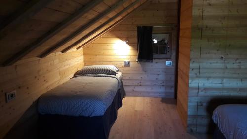 トゥエンノにあるChalet al Montの木製の壁にベッド2台が備わるベッドルーム1室