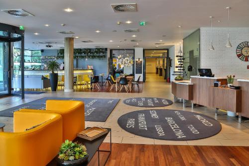 a lobby with a restaurant with chairs and tables at Hotel Frankfurt Messe Affiliated by Meliá in Frankfurt/Main