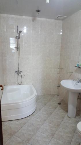 a bathroom with a white tub and a sink at Hotel Sali in Tbilisi City