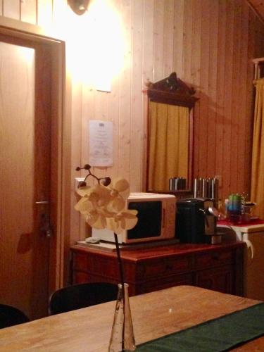 a vase of flowers on a table with a microwave at Eichhof Brienzwiler Berner Oberland in Brienzwiler