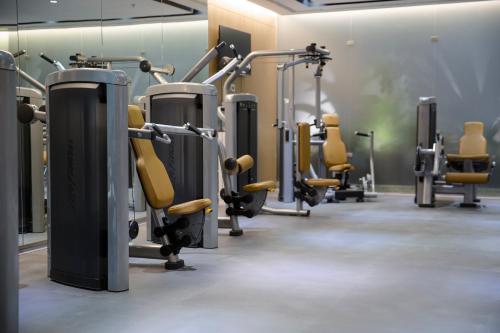 a gym with a row of treadmills and machines at Executives Hotel - KAFD in Riyadh
