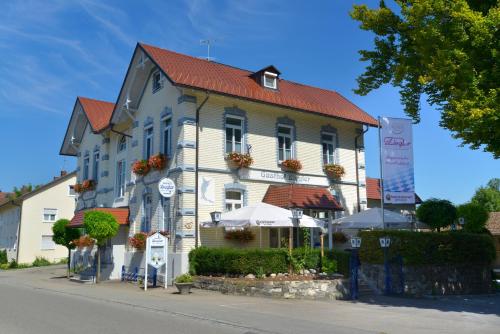 a building with a red roof on a street at Gasthof Ziegler Hotel & Restaurant in Lindau