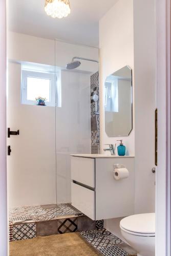 a white bathroom with a sink and a toilet at Studio L by MRG Apartments in Bucharest