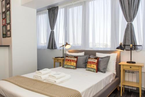a bedroom with a bed with white sheets and pillows at Studio L by MRG Apartments in Bucharest
