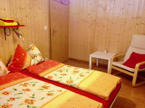 a room with two beds and a chair in it at Eichhof Brienzwiler Berner Oberland in Brienzwiler