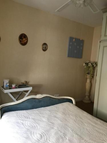 a bedroom with a bed and a wall with clocks at Les Fleurs in Monpazier