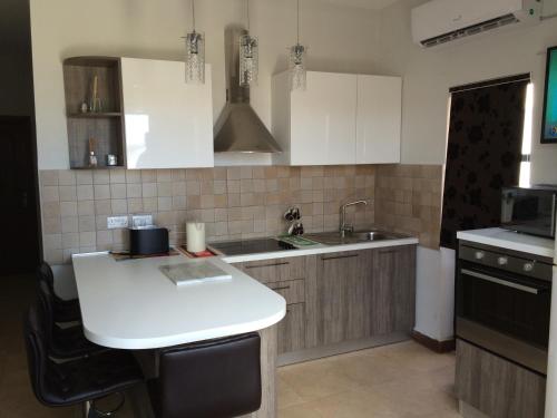 cocina con fregadero y encimera blanca en SEAVIEW Marsascala Apartment, en Marsaskala