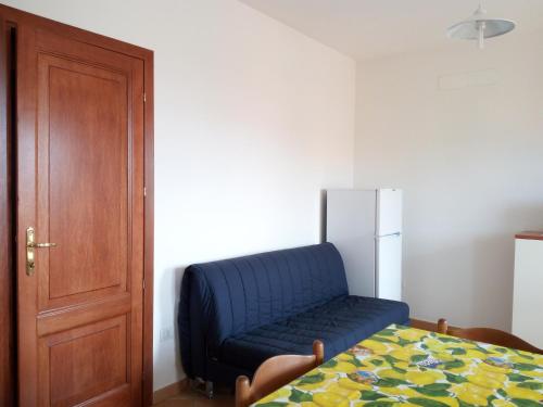 Sofá azul en una habitación con nevera en Apartment Olbia Holidays, en Olbia
