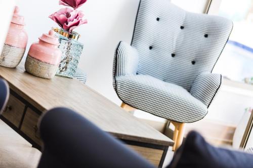a table with a chair and a vase with flowers at Menta City Boutique Hotel in Rethymno Town