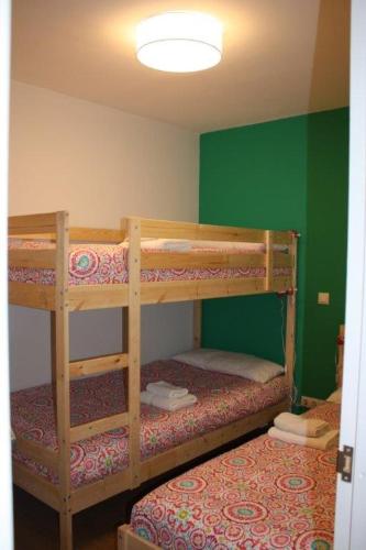 ビエラにあるApartamentos Vielha VIIIの緑の壁のドミトリールームの二段ベッド2台