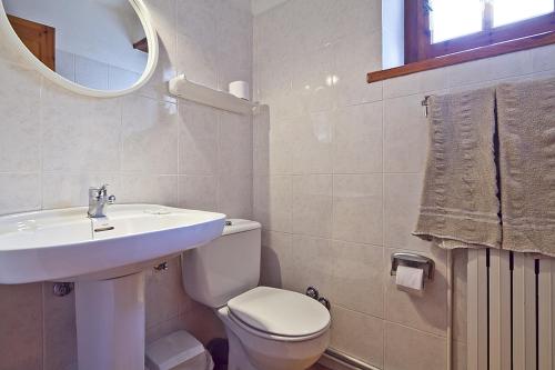 a bathroom with a sink and a toilet and a mirror at Apartamentos Salardu II in Salardú