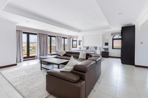 a living room with a couch and a table at Designer 3 Story Palm Villa in Dubai