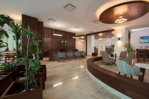 un vestíbulo de un restaurante con mesas y sillas en Altitude Level By Krystal Altitude Cancun - All Inclusive, en Cancún