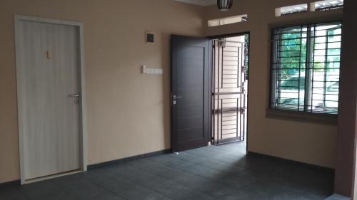 an empty hallway with a door and two windows at SleepRest - Plamo Garden in Batam Center