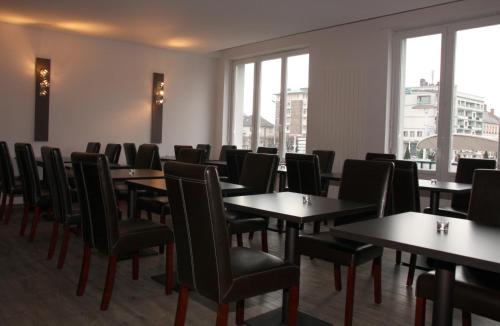 a dining room with tables and chairs and windows at Hôtel Bar le Globe in Saint Die