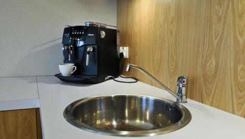 a kitchen counter with a sink and a coffee maker at IRS ROYAL APARTMENTS Apartamenty IRS Fregata in Gdańsk