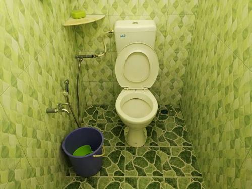 a small bathroom with a toilet and a bucket at Chalet Desa Halban in Kangar