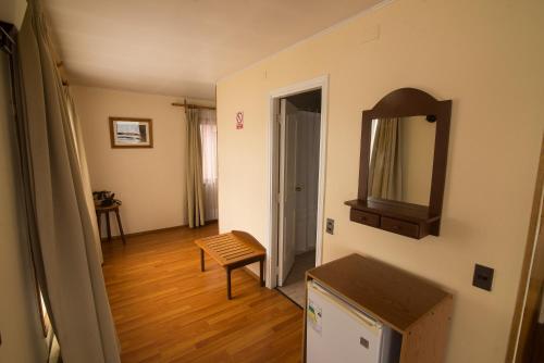 a room with a mirror and a wooden floor at Hotel Terrazas del Lago in Puerto Varas