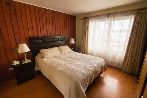 a bedroom with a large bed and a window at Hotel Terrazas del Lago in Puerto Varas