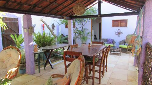 a patio with a wooden table and chairs at Pousada da Lucinha in Canoa Quebrada