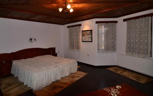 ein Schlafzimmer mit einem Bett und zwei Fenstern in der Unterkunft Art - M Gallery in Trjawna