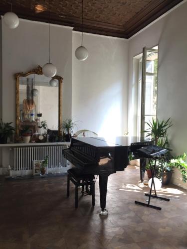 a black piano in a room with a mirror at Liberté in Marseille